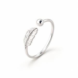 Silver-tone feather ring on a warm-white background