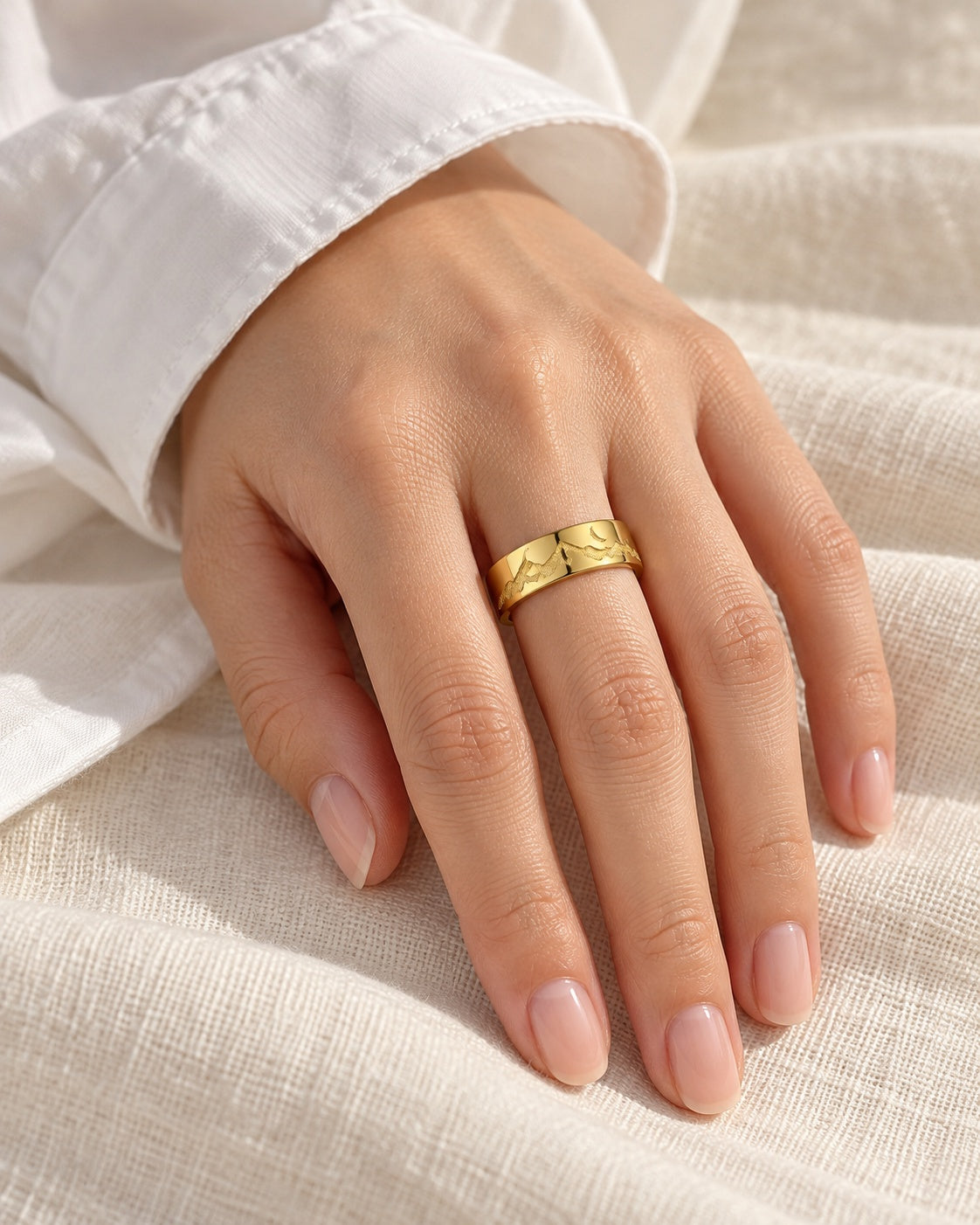 Gold-tone mountain and moon ring worn at natural scale; AI-generated brand photograph