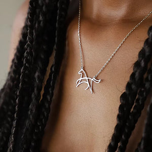 Silver-tone open-line horse pendant necklace worn between dark braids