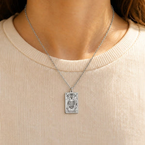 Silver The Devil tarot-card pendant necklace worn over a cream knit top.