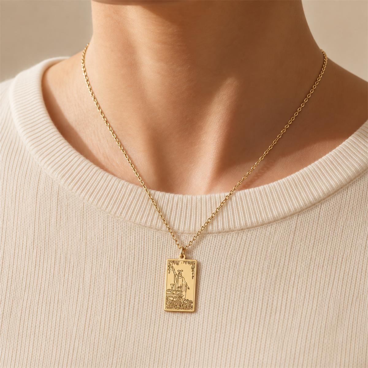 Gold The Magician tarot-card pendant necklace worn over a cream knit top.
