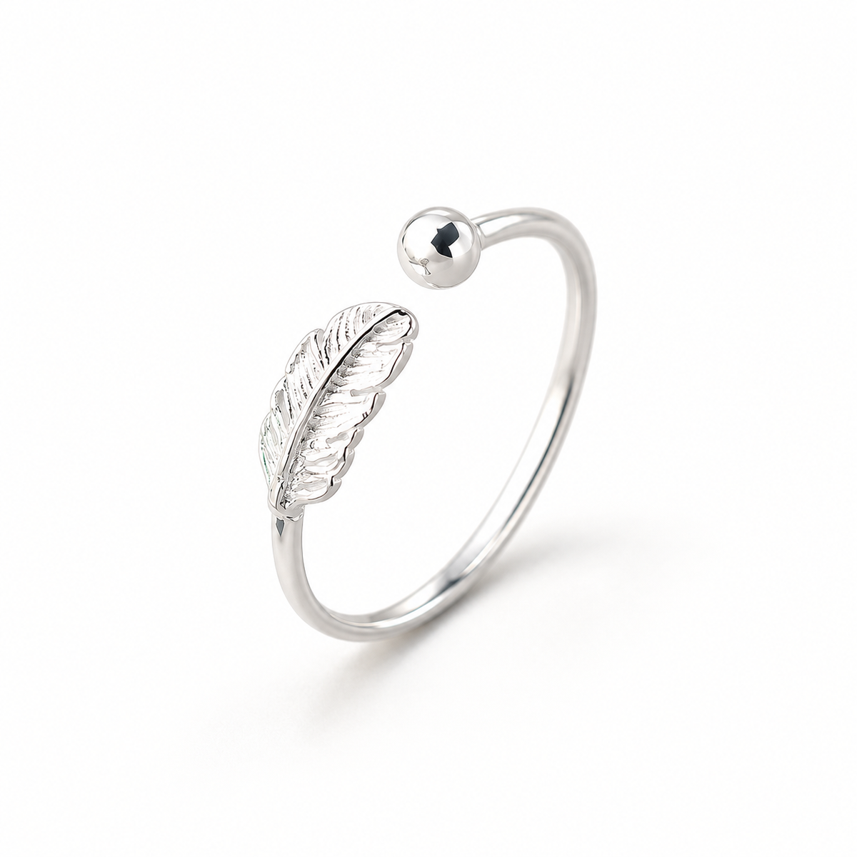 Silver-tone feather ring on a warm-white background