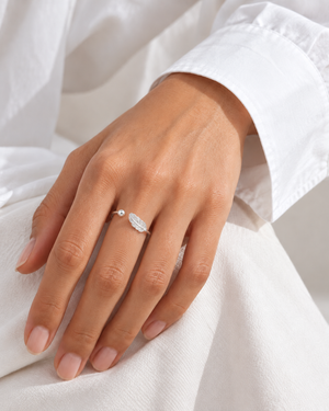 Silver-tone feather ring worn with a white shirt