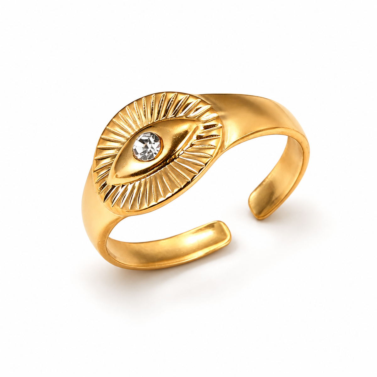 Gold-tone eye ring on a warm-white background