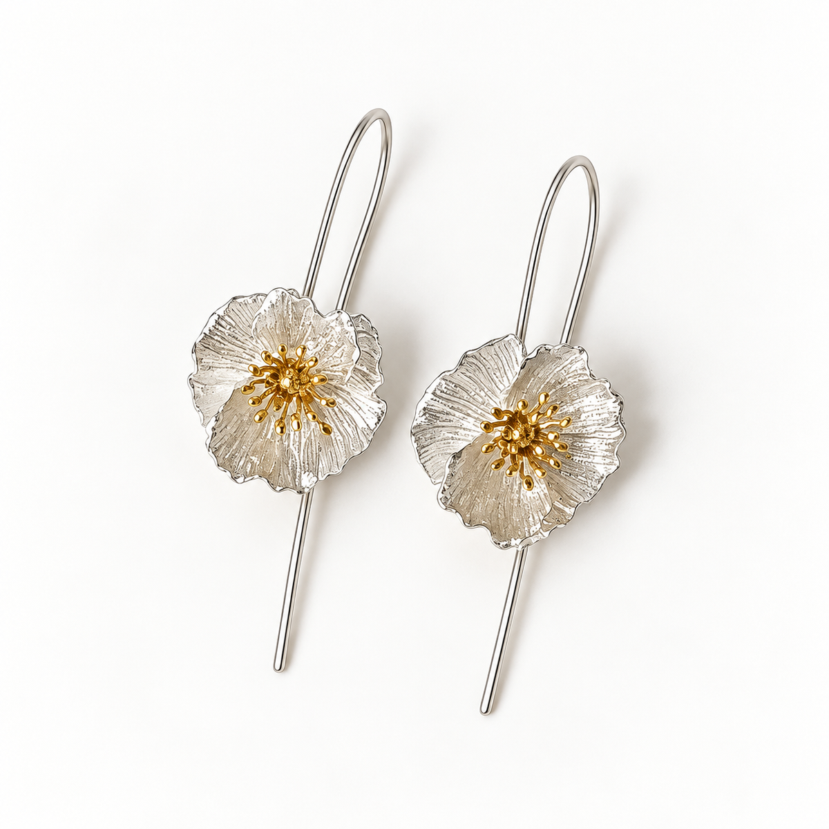 Silver-tone flower hook earrings on a warm-white background