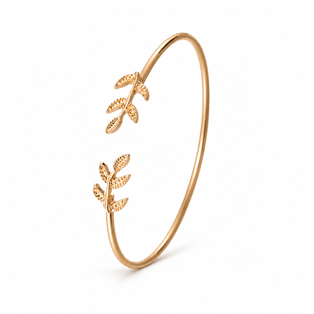 Gold-tone leaf cuff bracelet on a warm-white background