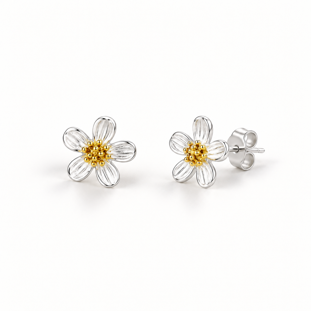 Silver-tone flower stud earrings on a warm-white background