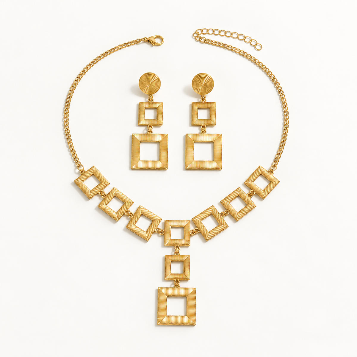 Gold-tone open square jewelry set on a plain warm-white background