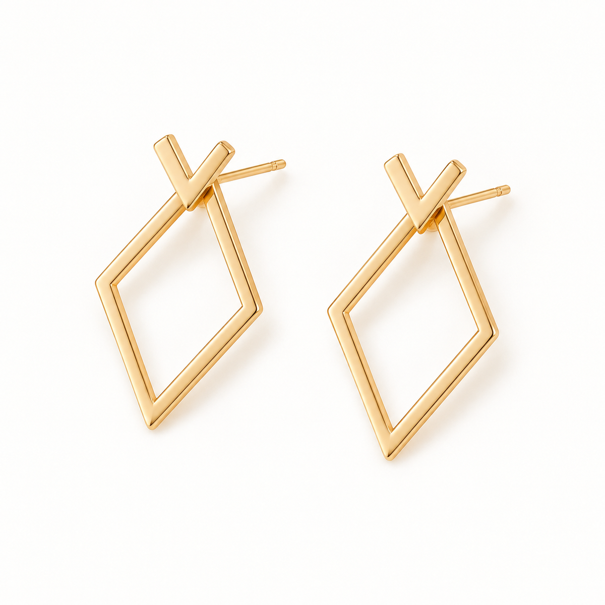 Gold-tone geometric jacket earrings on a warm-white background