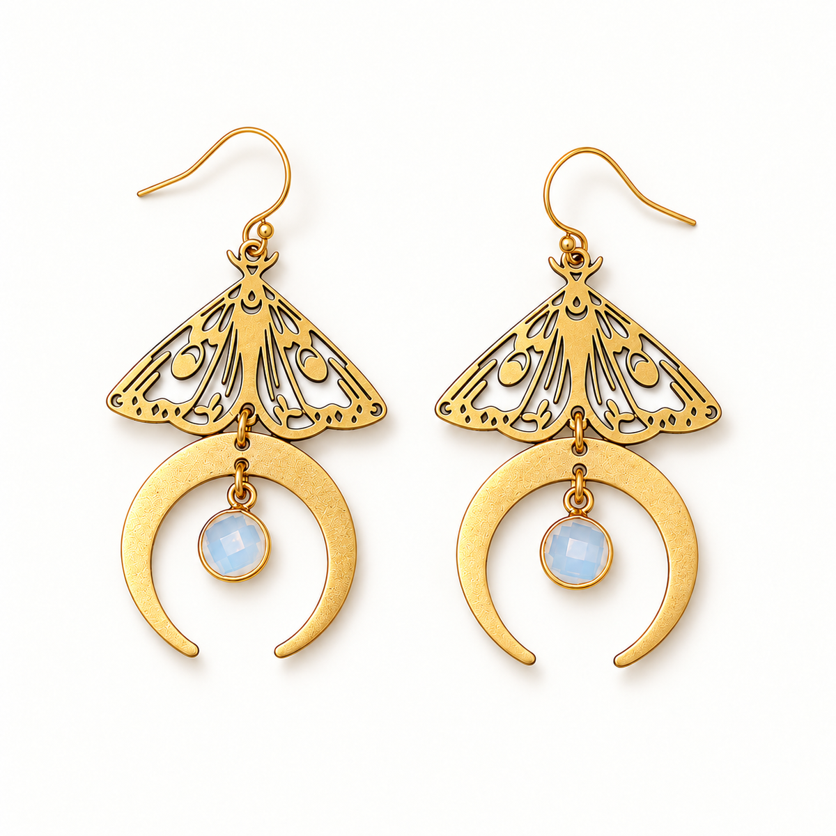 Gold-tone moth moon earrings on a warm-white background