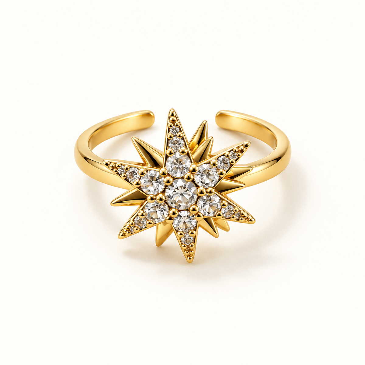 Gold-tone starburst ring on a warm-white background