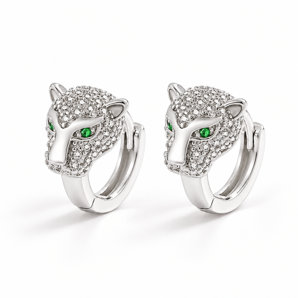 Silver-tone leopard hoop earrings on a warm-white background