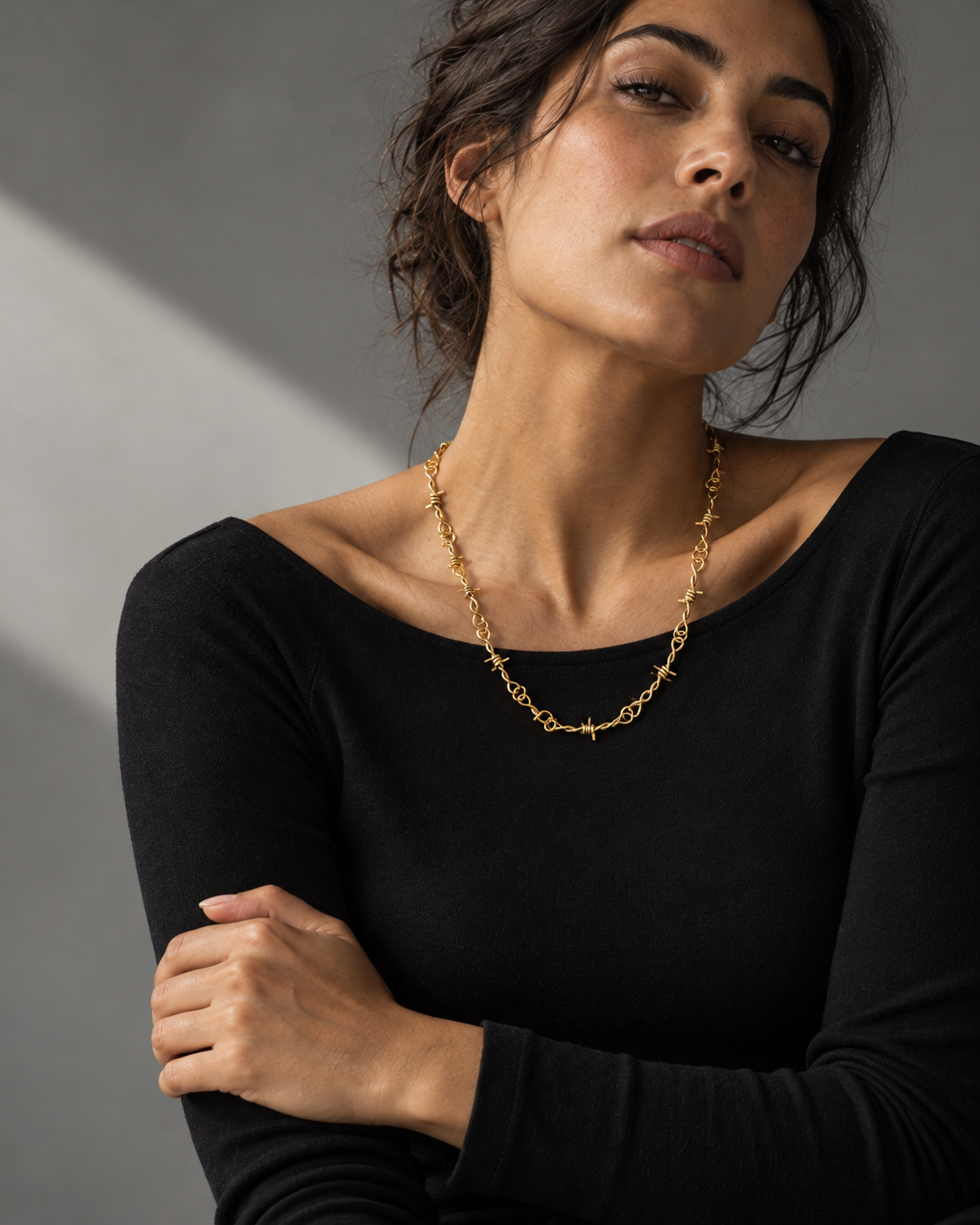 Gold-tone barbed link necklace worn at natural scale; AI-generated brand photograph