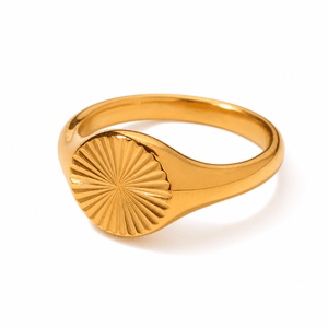 Gold-tone ring with radiating lines across an oval face