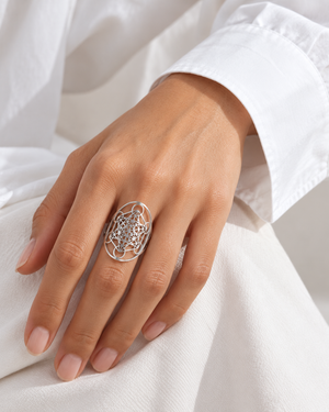 Silver-tone geometry ring worn at natural scale; AI-generated brand photograph