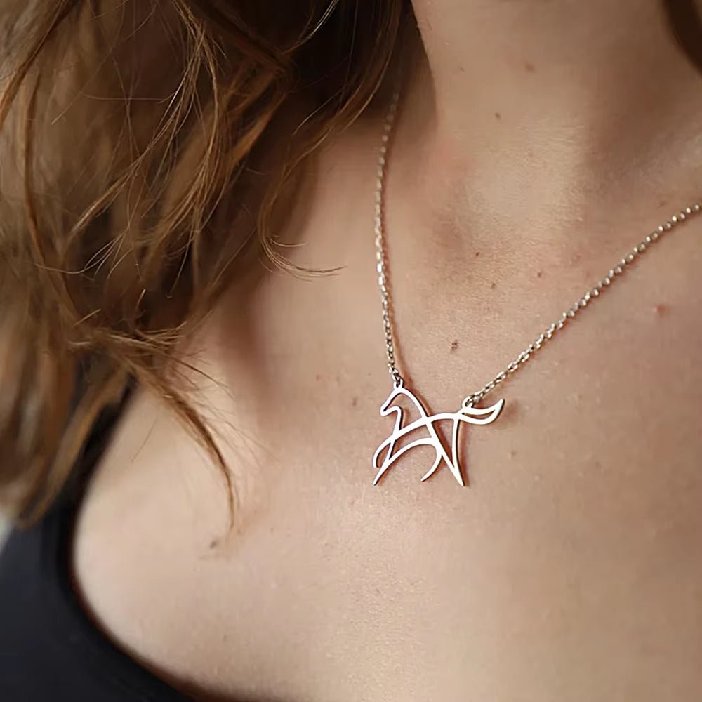 Silver-tone open-line horse necklace worn with a dark neckline
