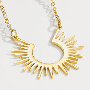 Close-up of the slender gold-tone rays around an open sun pendant